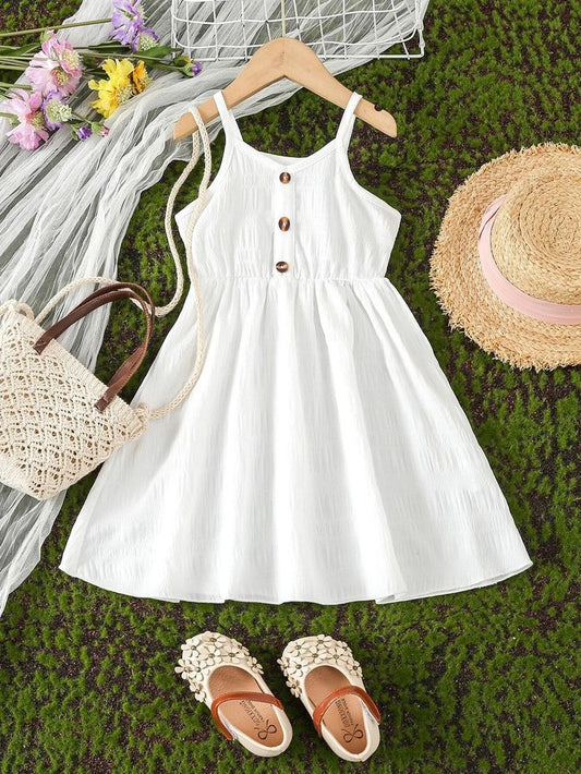 wearing a straw hat and floral sandals, playing joyfully outdoors on green grass.
