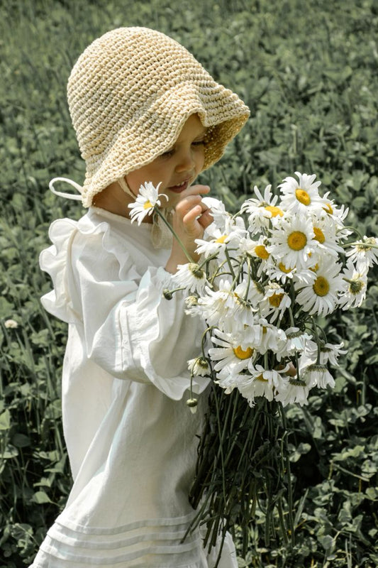 Toddler girl in vintage white frock in nature
