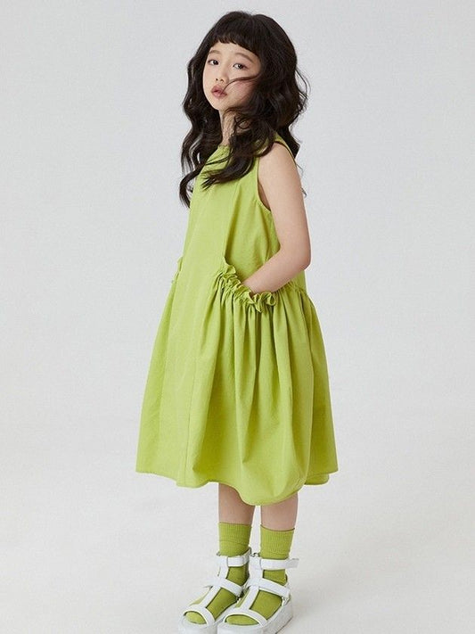 Girl in lime green sleeveless dress with pocket

