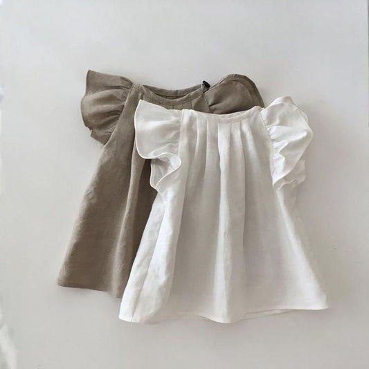 Two minimalist baby girl tops in soft, neutral shades